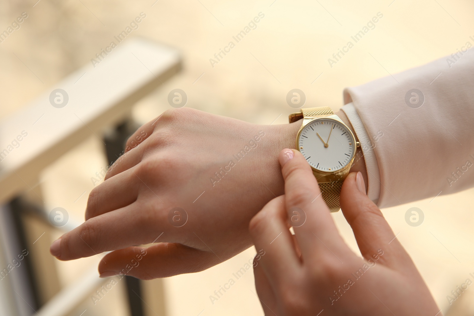 Photo of Woman with luxury wristwatch on blurred background, closeup