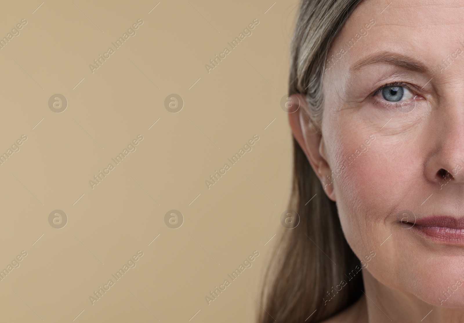 Photo of Senior woman with aging skin on beige background, closeup and space for text. Rejuvenation treatment