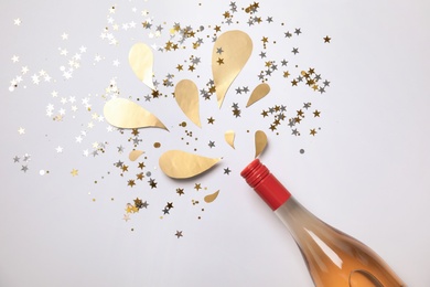 Creative flat lay composition with bottle of champagne on white background