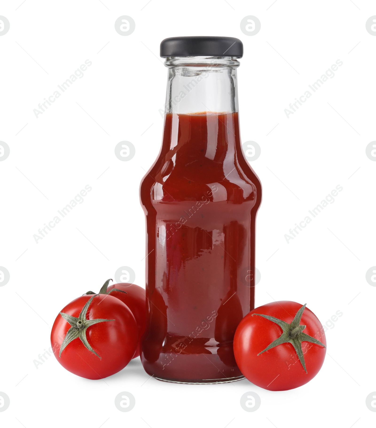 Photo of Glass bottle of tasty ketchup and fresh tomatoes isolated on white