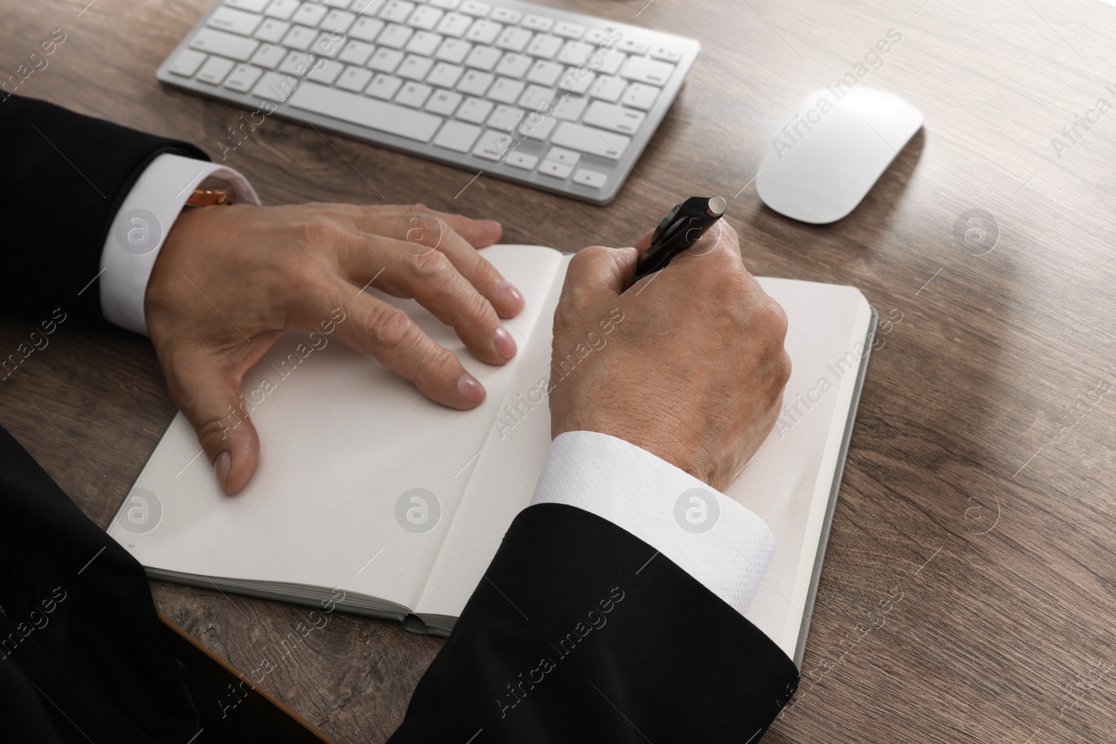 Photo of Boss working at wooden table indoors, closeup