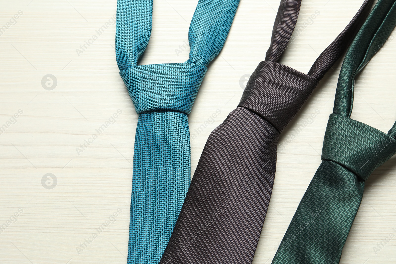 Photo of Different neckties on white wooden table, flat lay. Space for text