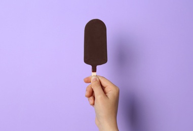 Photo of Woman holding delicious ice cream with chocolate against color background