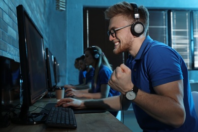 Emotional man playing video game in internet cafe