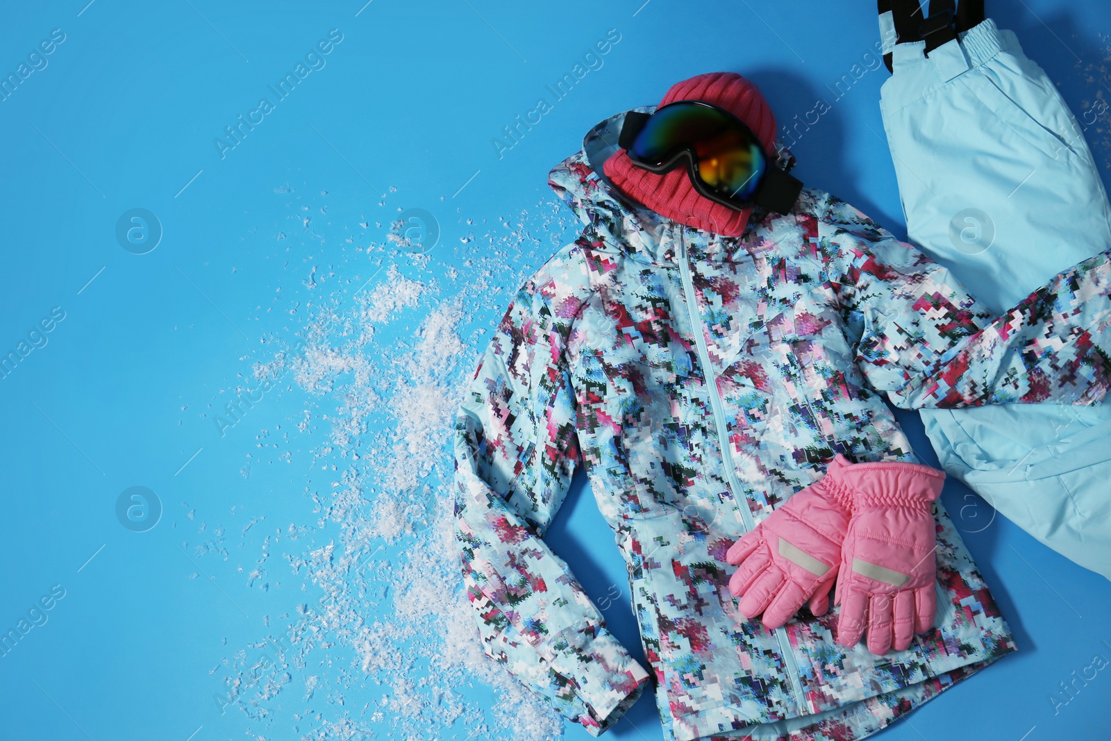 Photo of Stylish winter sport clothes on light blue background, flat lay. Space for text