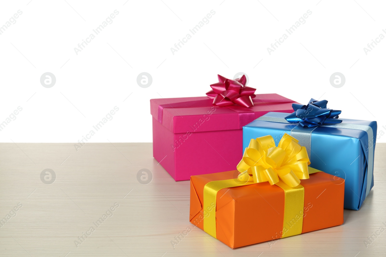 Photo of Colorful gift boxes on wooden table against white background, space for text