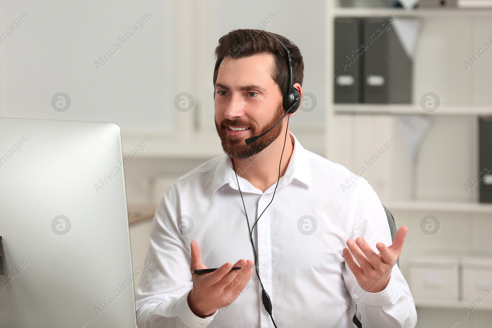 Photo of Hotline operator with headset working in office