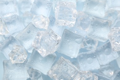 Photo of Crystal clear ice cubes on light blue background, flat lay