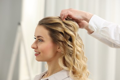 Photo of Hair styling. Professional hairdresser working with smiling client indoors, closeup