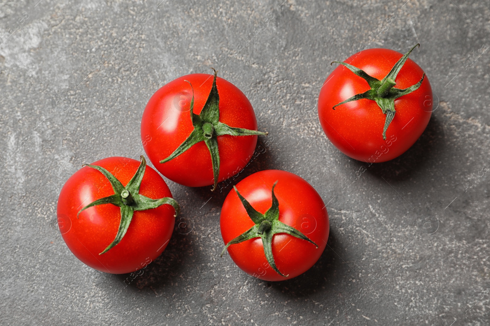 Photo of Fresh cherry tomatoes on stone background, top view