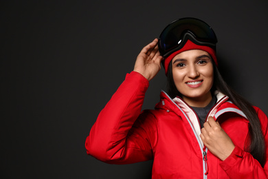 Photo of Woman wearing stylish winter sport clothes on black background