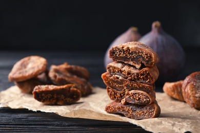 Photo of Delicious dried figs on parchment, closeup. Organic snack