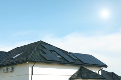 Photo of House with installed solar panels on roof, space for text. Alternative energy