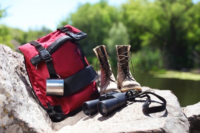 Photo of Traveling gear on rock near river. Summer camp