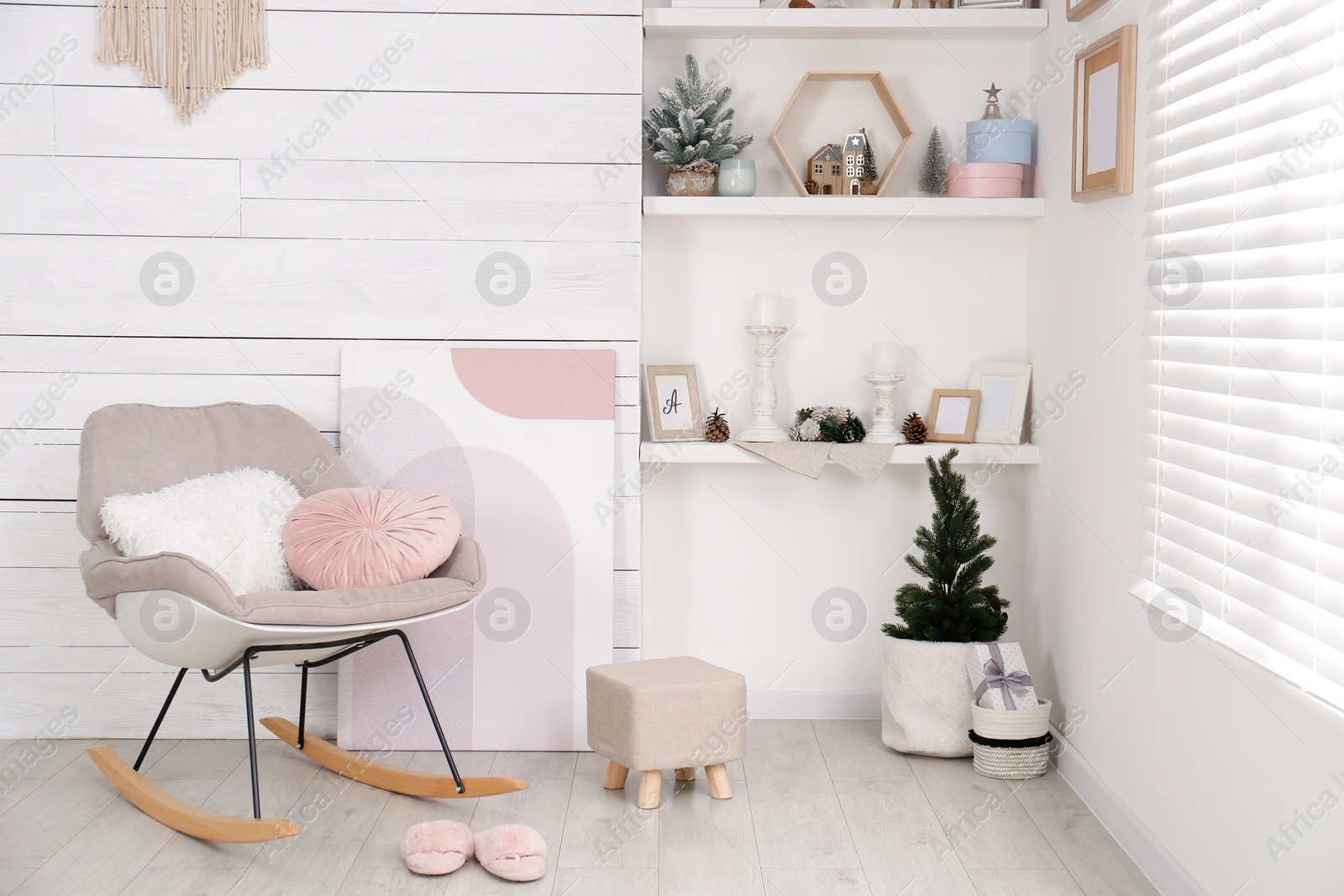 Photo of Stylish room interior with rocking chair, wall shelves and beautiful Christmas decor