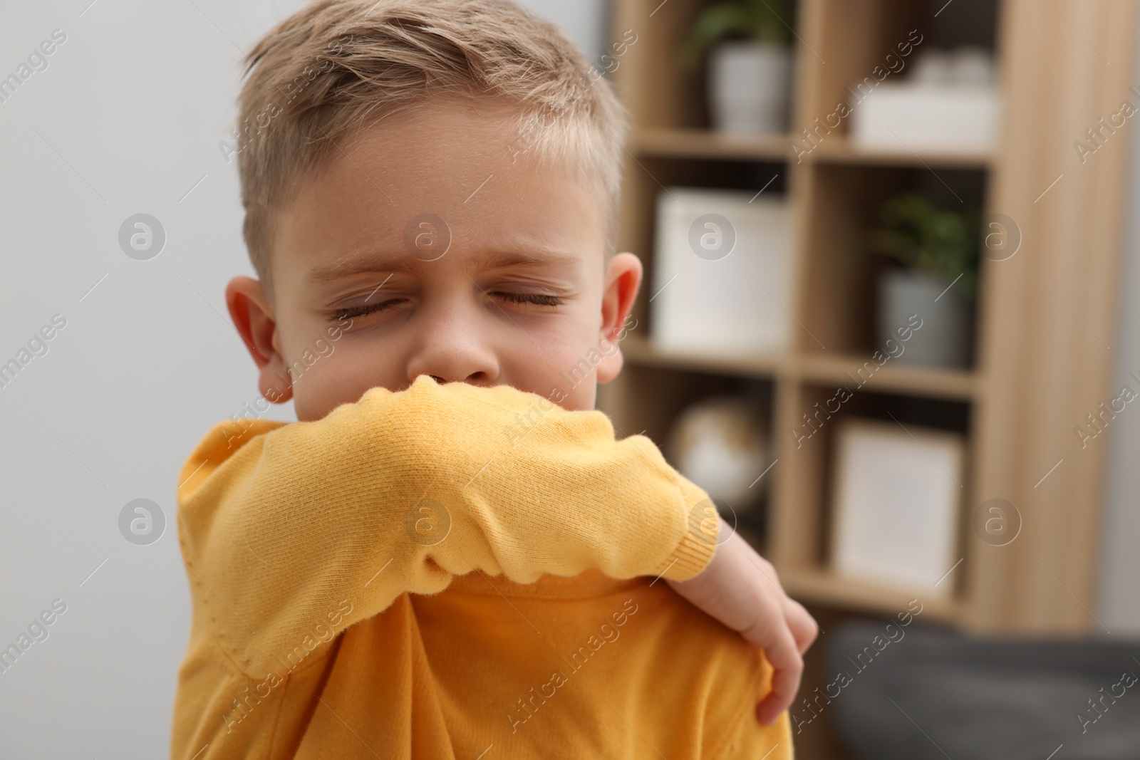 Photo of Sick boy coughing at home. Cold symptoms