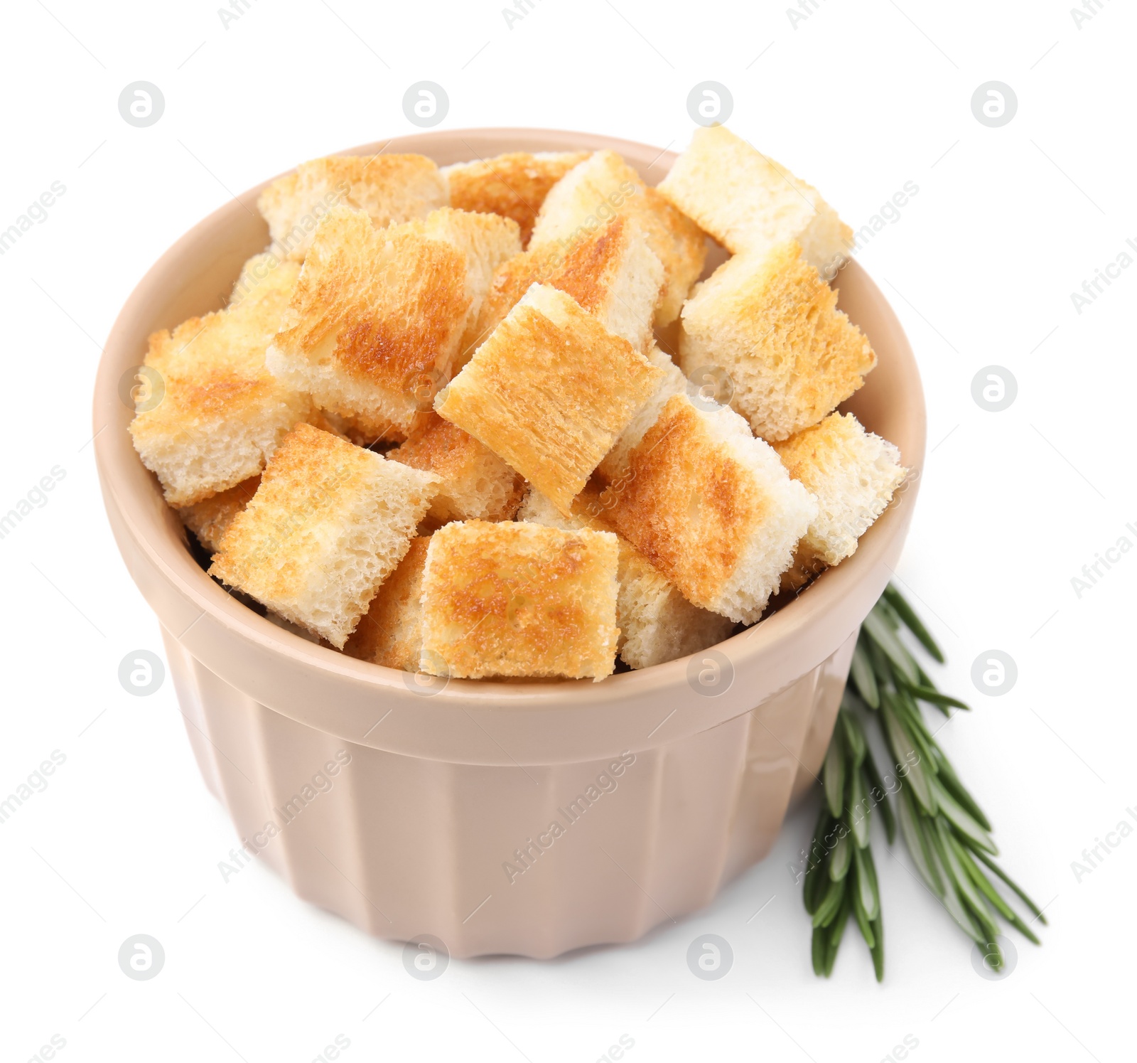 Photo of Delicious crispy croutons in bowl and rosemary on white background