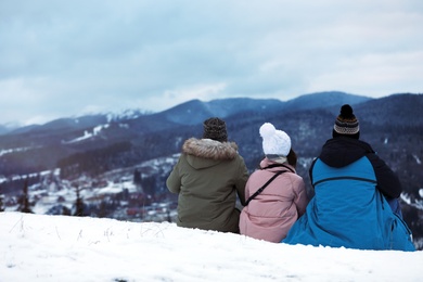 Friends enjoying mountain landscape, space for text. Winter vacation