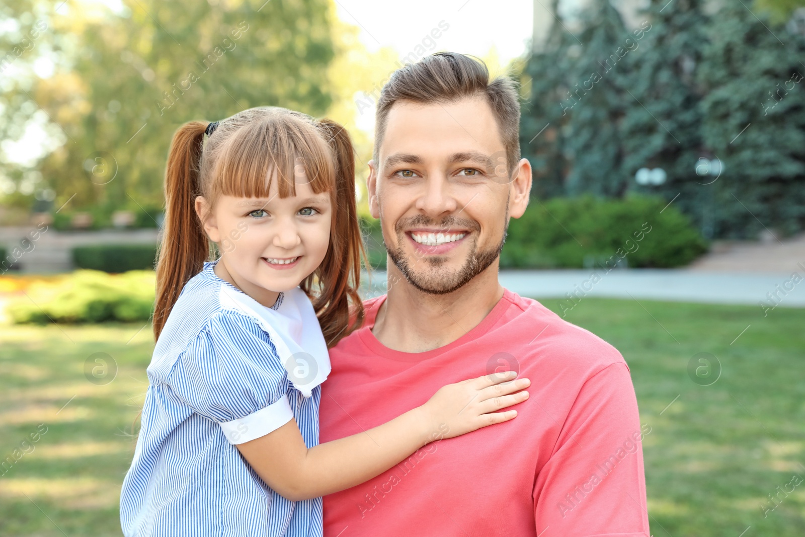 Photo of Father with his cute child in green park on sunny day. Happy family