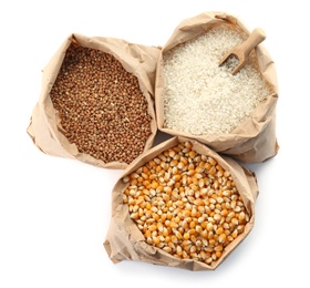 Photo of Paper bags with different types of grains and cereals on white background