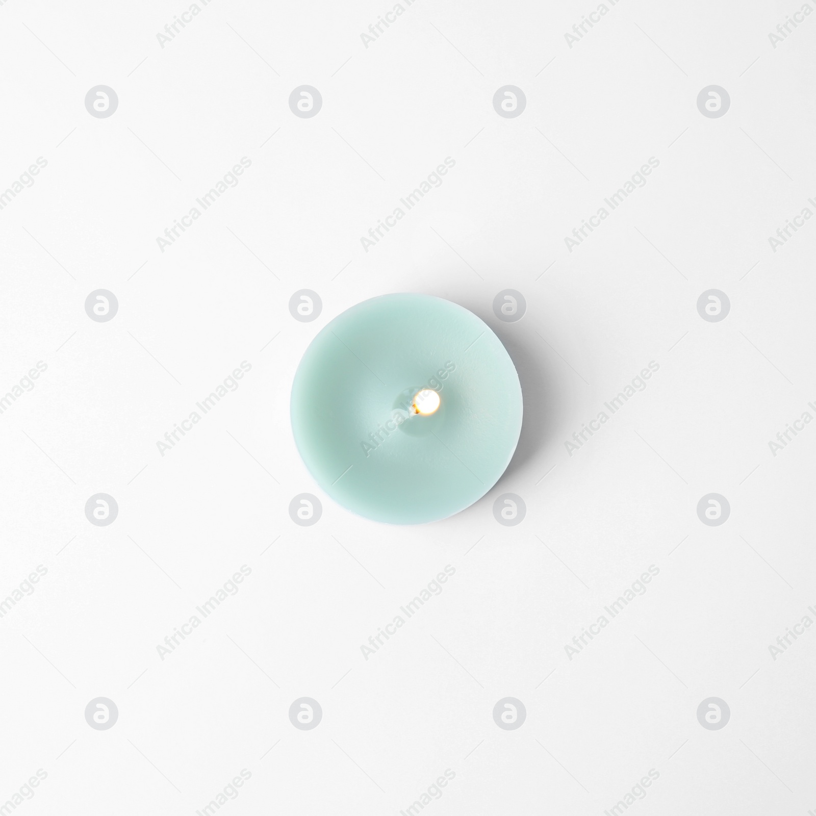 Photo of Light blue wax decorative candle isolated on white, top view
