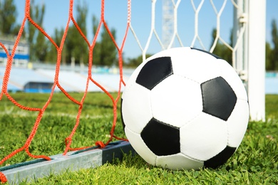 Photo of Soccer ball near net on green football field grass