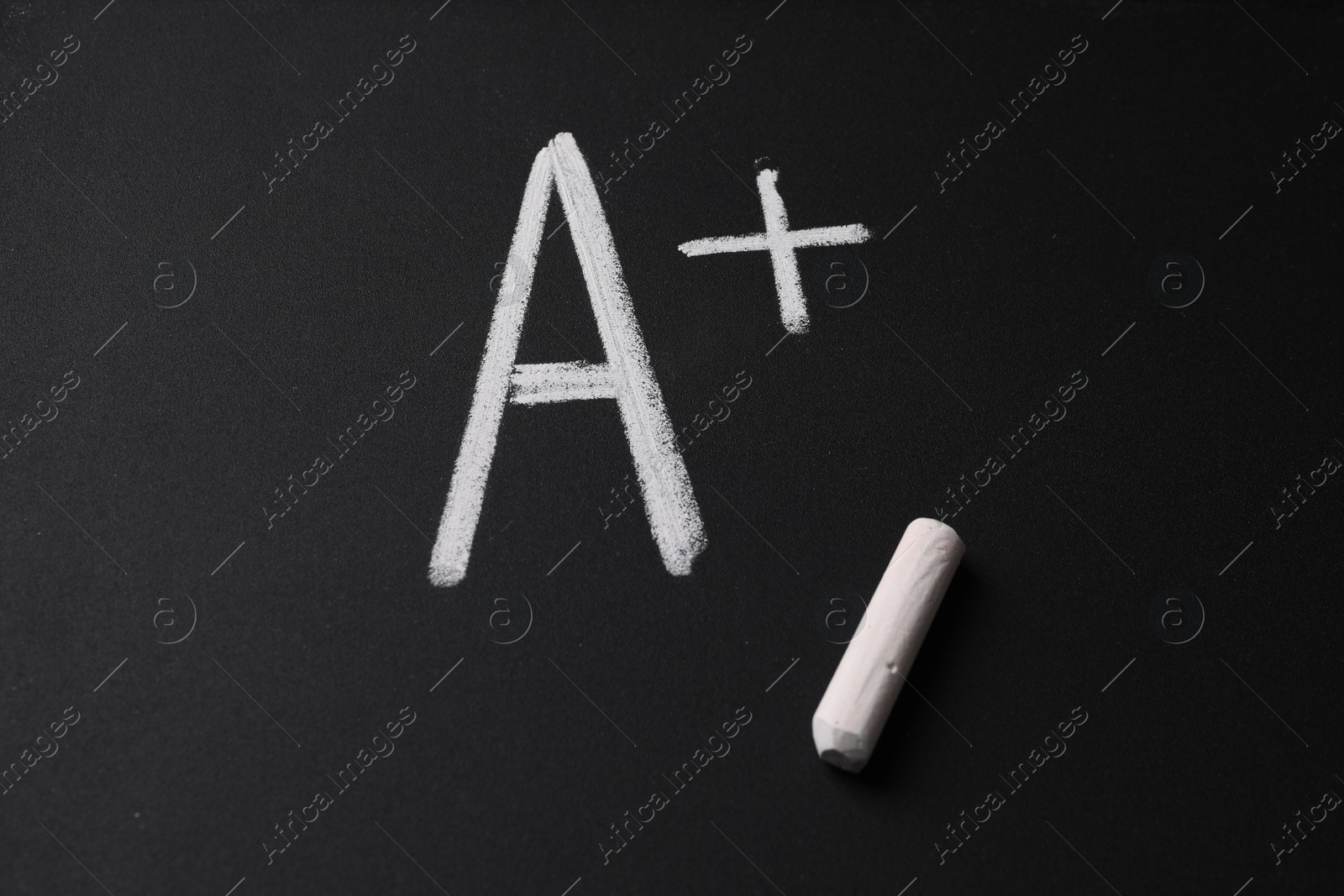 Photo of School grade. Letter A with plus symbol and chalk on blackboard, top view