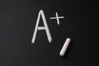 Photo of School grade. Letter A with plus symbol and chalk on blackboard, top view