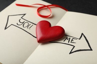 Photo of Heart between arrows with words YOU and ME pointing in different directions on notepad. Composition symbolizing relationship problems