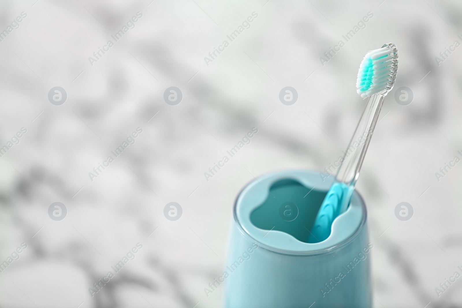 Photo of Cup with toothbrush on table. Dental care