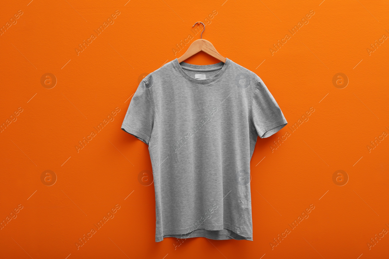 Photo of Hanger with blank t-shirt on color background. Mockup for design