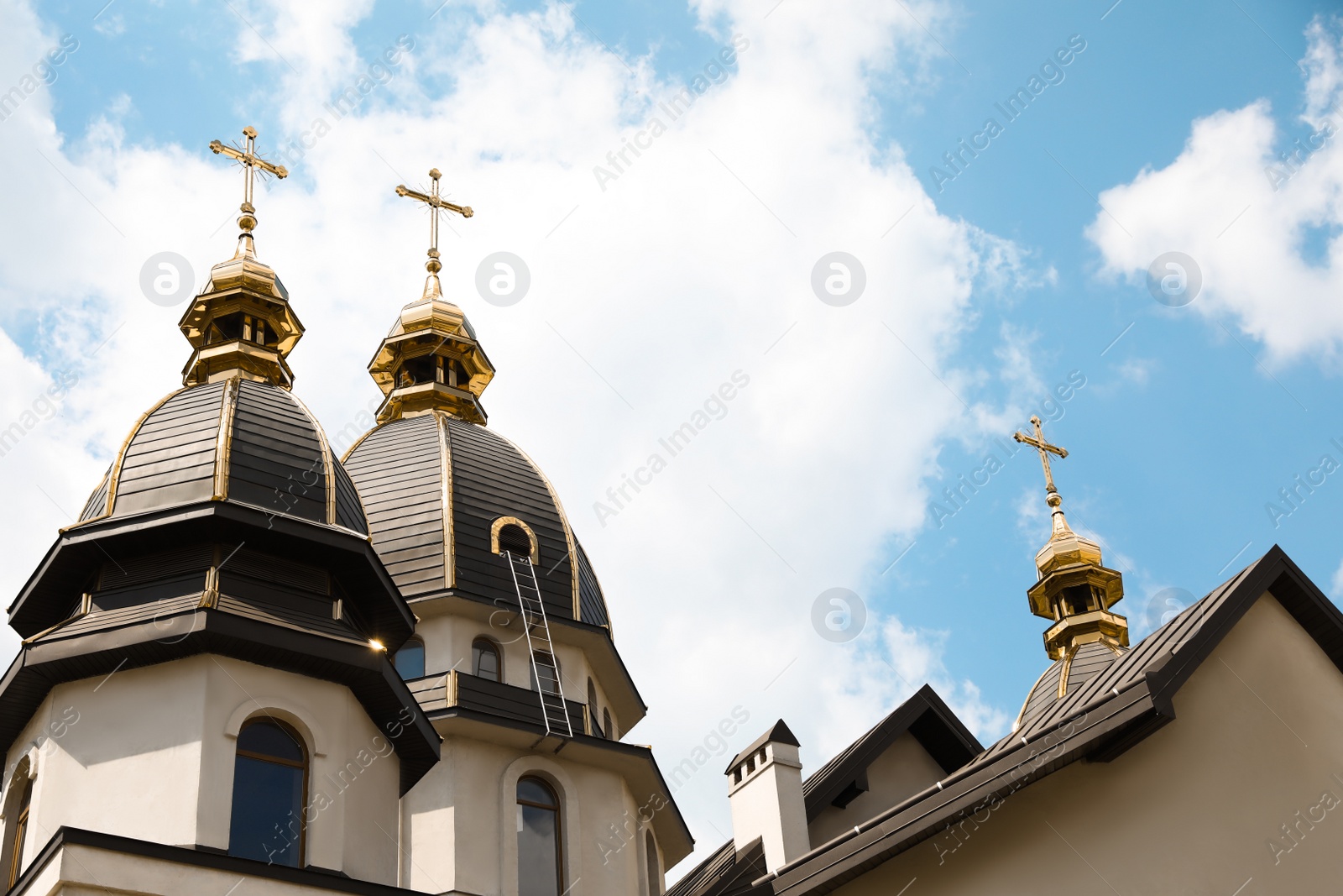 Photo of Beautiful church with golden domes against cloudy sky