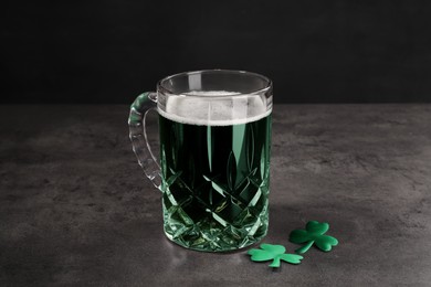 St. Patrick's day celebration. Green beer with decorative clover leaves on grey table