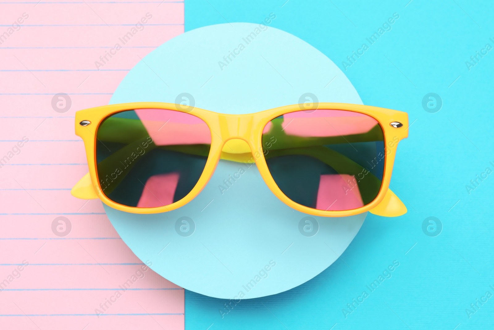 Photo of Stylish sunglasses on color background, top view