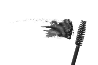 Photo of Smear of mascara and applicator isolated on white, top view