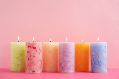 Photo of Alight scented wax candles on color background