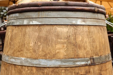 Photo of Traditional wooden barrel outdoors, closeup. Wine making