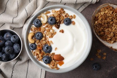 Bowl with yogurt, blueberries and granola on grey table, top view