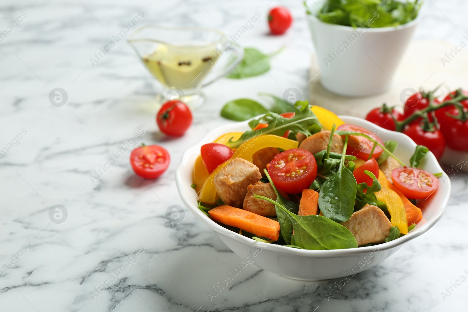 Photo of Delicious fresh chicken salad on white marble table. Space for text