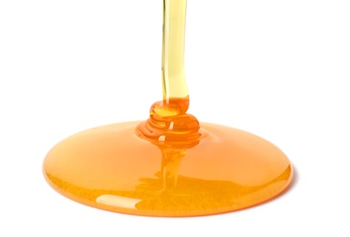 Pouring fresh sweet honey on white background