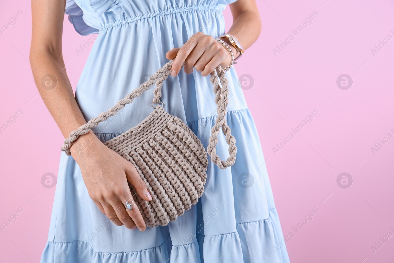 Photo of Young woman in stylish outfit with purse on color background, closeup