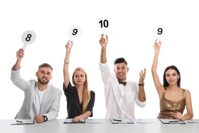 Photo of Panel of judges holding different score signs at table on white background