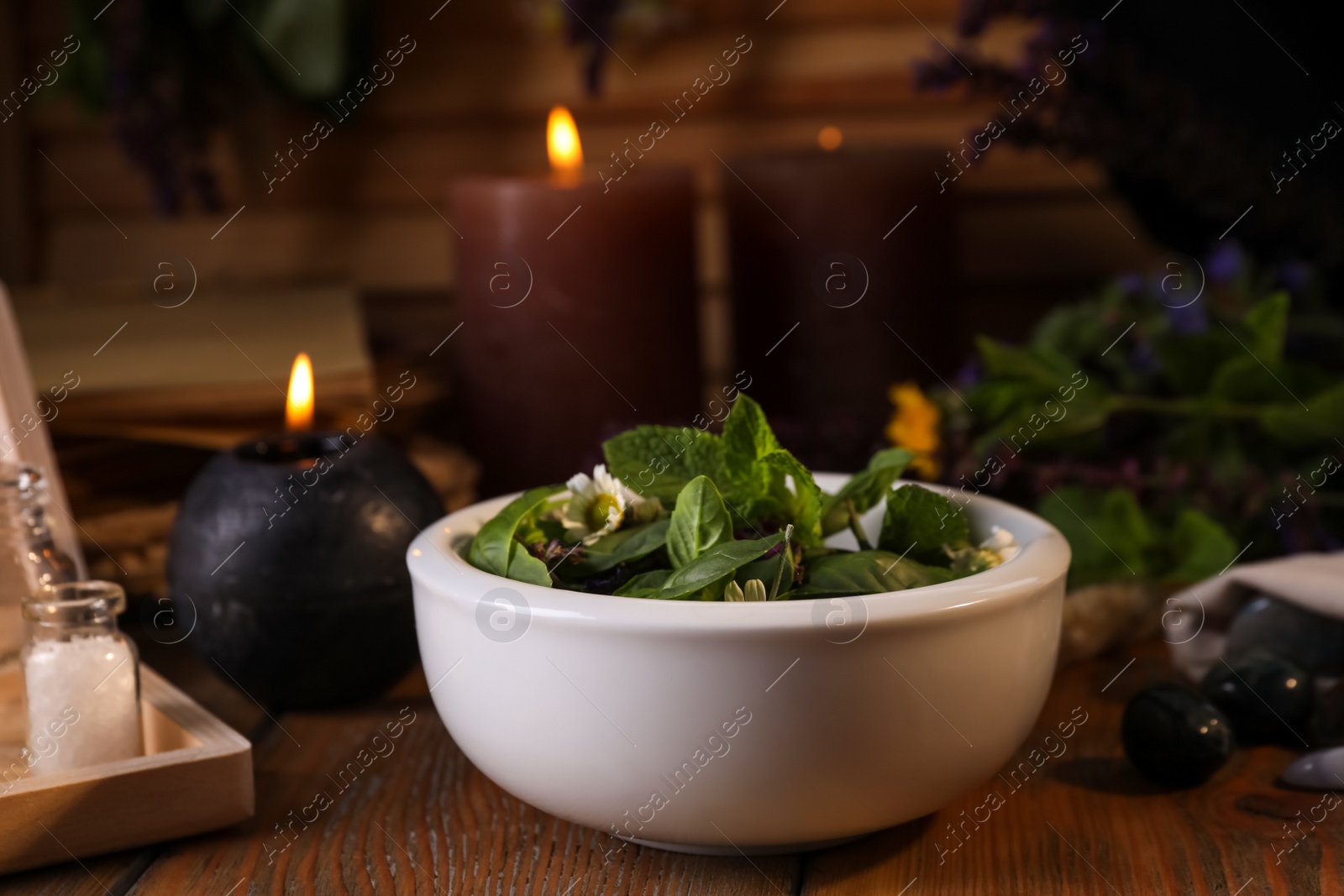 Photo of Composition with mortar, healing herbs and gemstones on wooden table