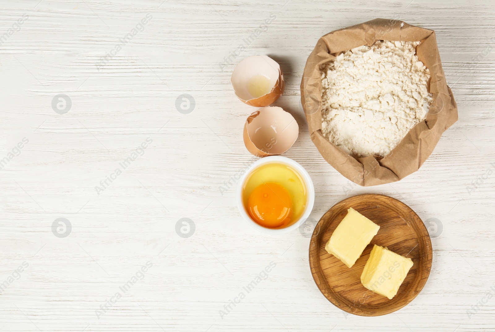 Photo of Flat lay composition with eggs and other ingredients  on white wooden table, space for text. Baking pie