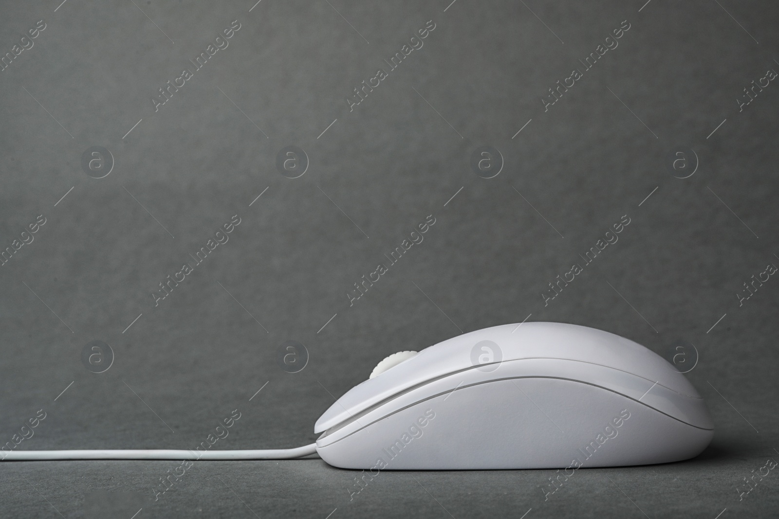 Photo of Modern wired computer mouse on grey background. Space for text