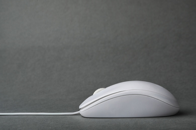 Photo of Modern wired computer mouse on grey background. Space for text