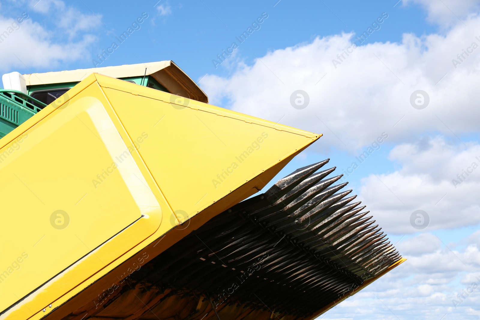 Photo of Modern combine harvester in agricultural field, closeup