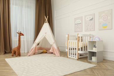 Photo of Cute baby room interior with crib and play tent