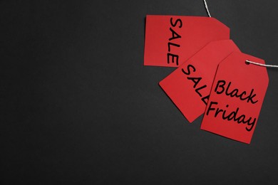 Photo of Red tags with words Black Friday and Sale on color background, flat lay. Space for text