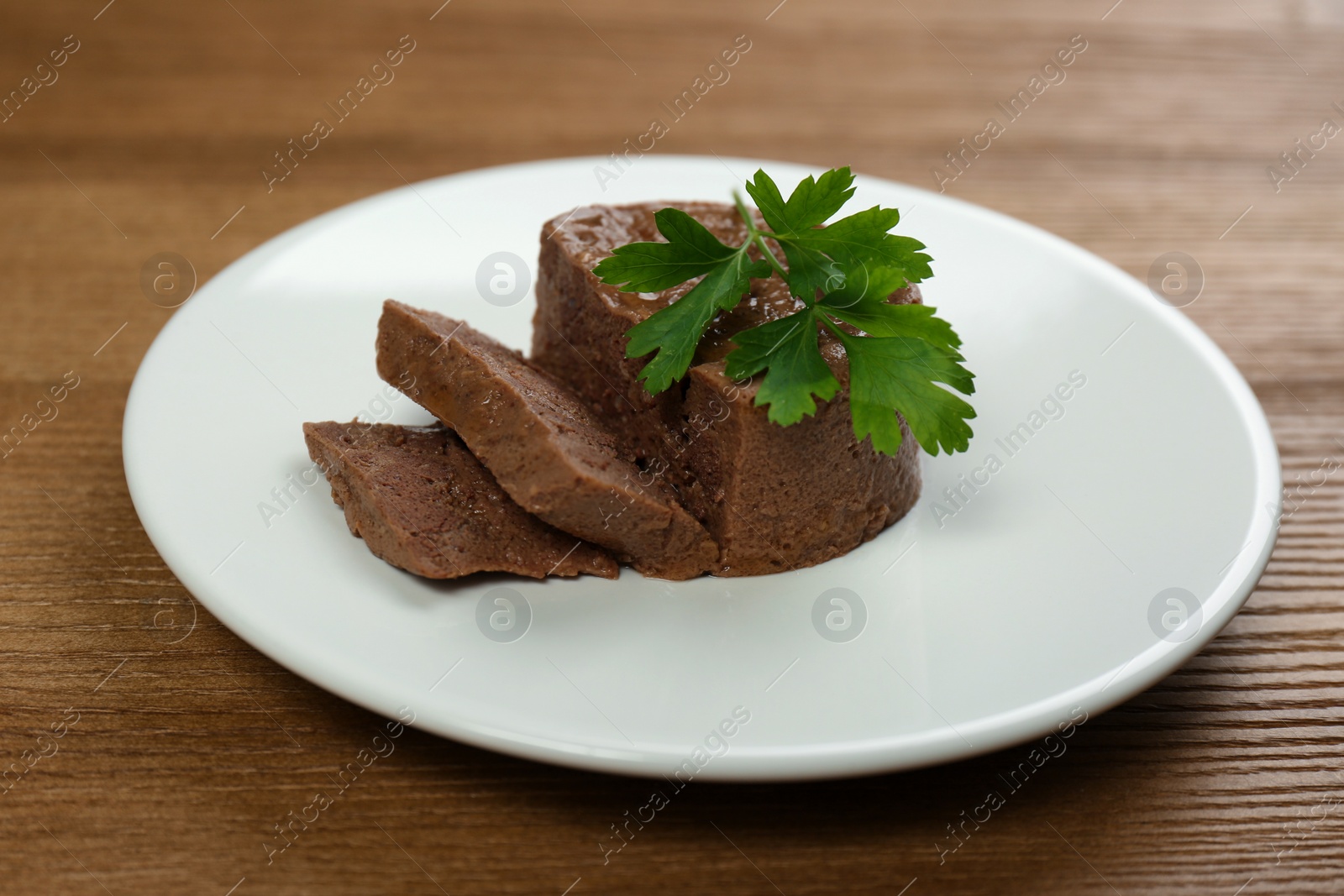 Photo of Plate with pate and parsley on wooden table. Pet food